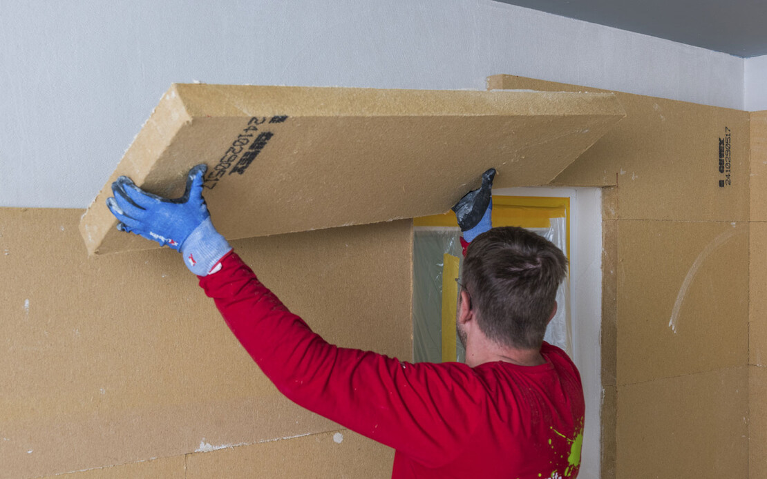 Die Holzfaserdämmplatte Thermoroom wird an die Wand geklebt.